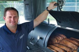 Relocation General Manager, Bryan Oler, inspects some Texas-style barbecue at the company’s annual customer appreciation event in Houston.