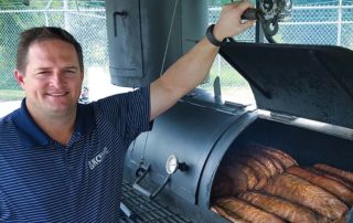 Relocation General Manager, Bryan Oler, inspects some Texas-style barbecue at the company’s annual customer appreciation event in Houston.