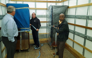 From the classroom into the truck—crew members got hands-on training learning the IOMI® floating method of keeping the furniture on the dolly on the floor of the truck.